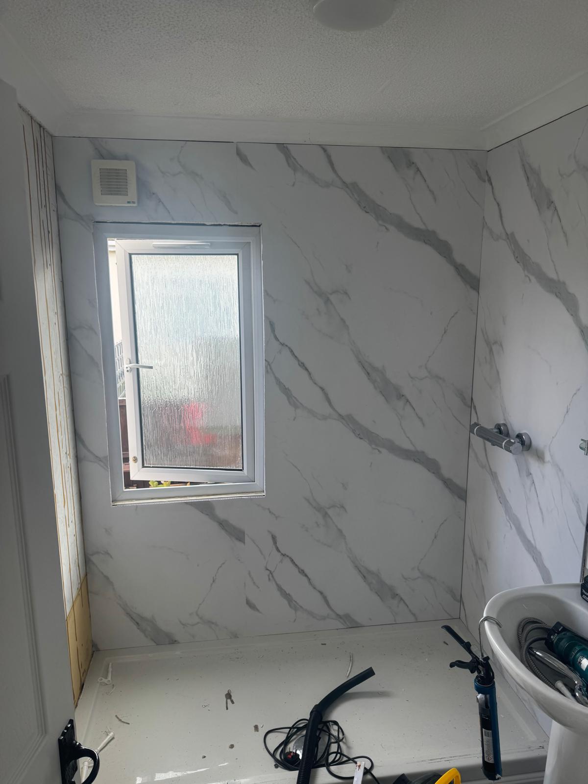 Marble-effect bathroom wall panels being installed by Reactive in Leicestershire